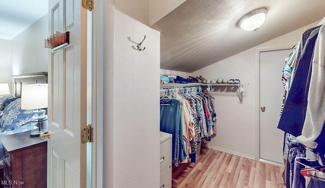 spacious closet featuring wood finished floors and vaulted ceiling