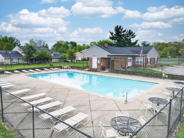 community pool with fence and a patio