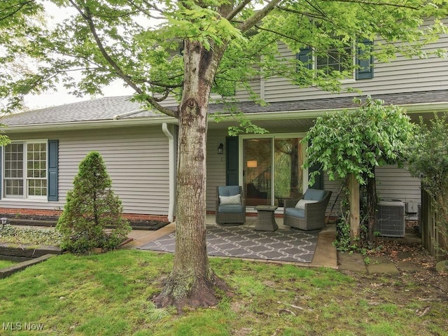 rear view of house with central air condition unit and a patio area