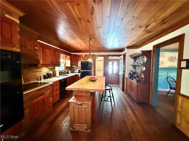 6859 Fairground Blvd, Canfield, OH 44406 - kitchen with wood counters, black appliances, a sink, a breakfast bar, and a center island
