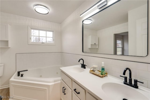 2875 Sherwood Ave NW, Massillon, OH 44646 - full bathroom with a tub with jets, decorative backsplash, double vanity, and wood finished floors