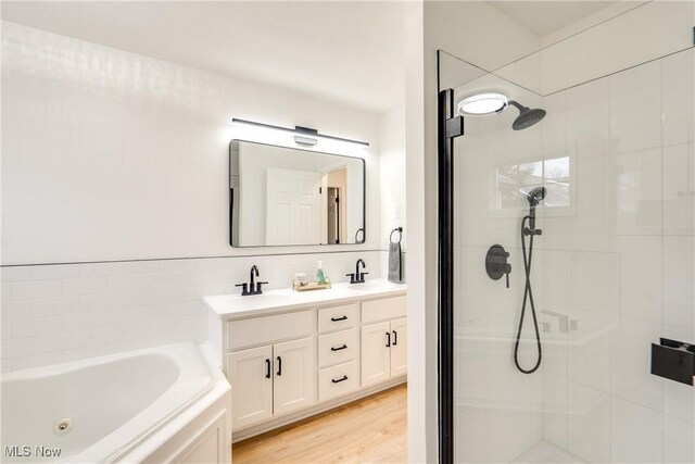 2875 Sherwood Ave NW, Massillon, OH 44646 - bathroom with a shower stall, a tub with jets, double vanity, and wood finished floors