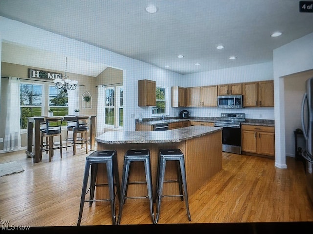 1614 Bellview St NE, Canton, OH 44721 - kitchen with stainless steel appliances, brown cabinets, a chandelier, a kitchen island, and healthy amount of natural light