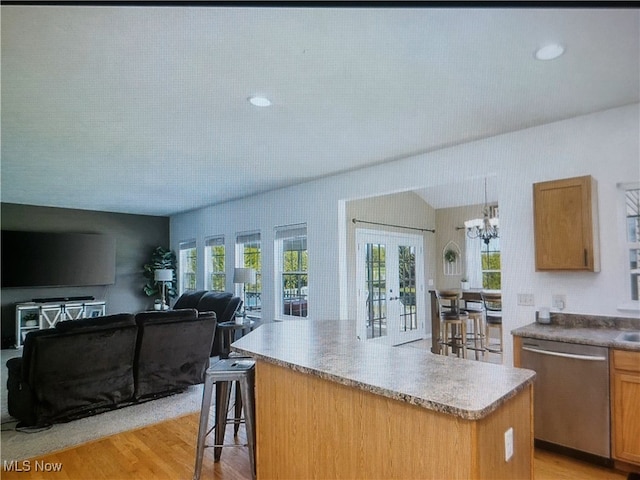 1614 Bellview St NE, Canton, OH 44721 - kitchen with stainless steel dishwasher, open floor plan, light wood-style flooring, a center island, and a breakfast bar area