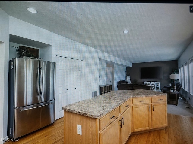 1614 Bellview St NE, Canton, OH 44721 - kitchen featuring freestanding refrigerator, light wood finished floors, open floor plan, a kitchen island, and light brown cabinets