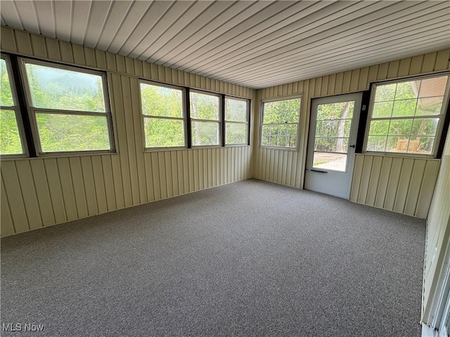 unfurnished sunroom featuring carpet floors and healthy amount of natural light