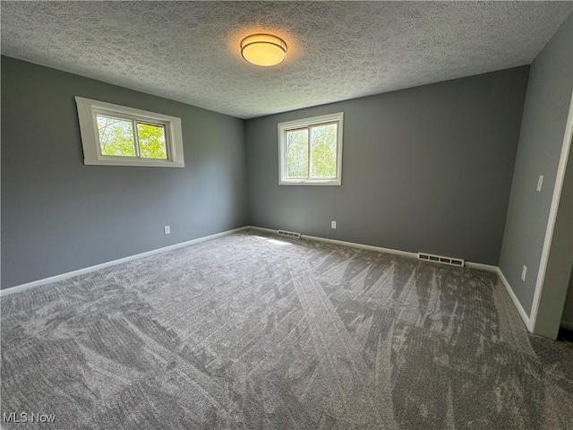 carpeted spare room with baseboards and a textured ceiling