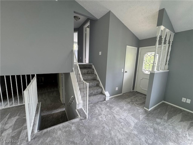 staircase featuring carpet flooring, lofted ceiling, baseboards, and a textured ceiling