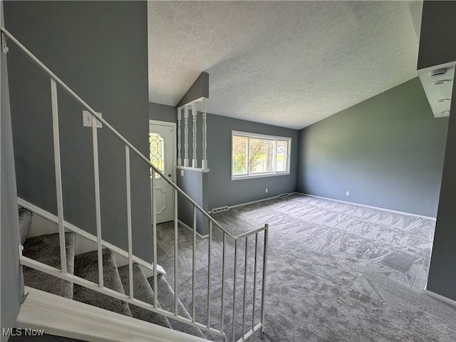 stairs featuring a textured ceiling, carpet flooring, and baseboards