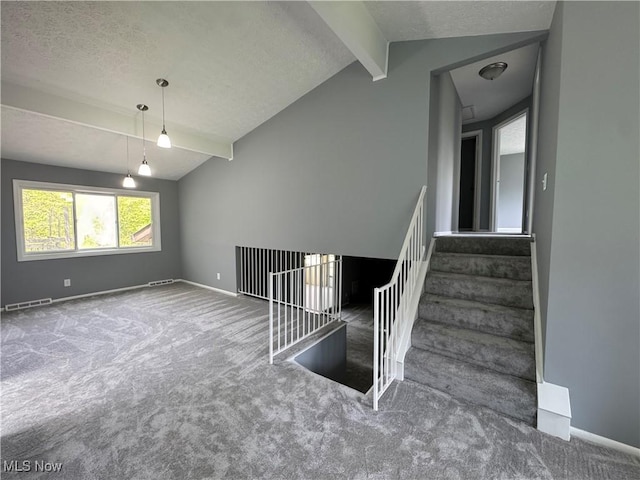 staircase with carpet, baseboards, and a textured ceiling