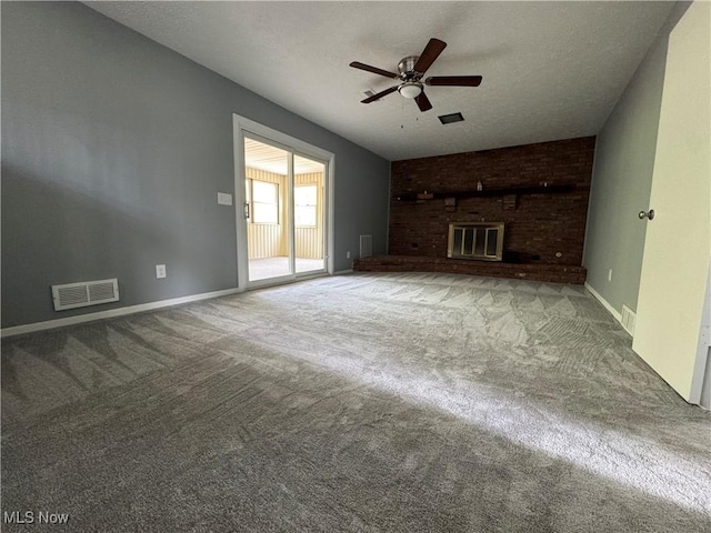 unfurnished living room with ceiling fan, carpet flooring, a textured ceiling, and a brick fireplace