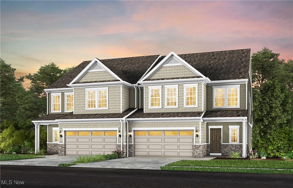 180 Lake Balaton Dr, Orange, OH 44128 - view of front of house featuring stone siding, an attached garage, driveway, and roof with shingles