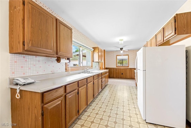 kitchen featuring freestanding refrigerator, light floors, wallpapered walls, healthy amount of natural light, and light countertops