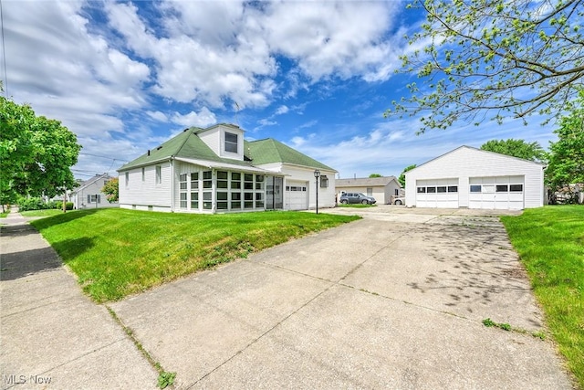 view of front of house with a garage, a front yard, and a sunroom