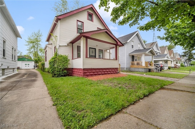 3692 E 118th St, Cleveland, OH 44105 - view of front of house with concrete driveway, a garage, covered porch, a front yard, and an outbuilding