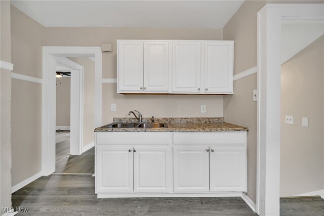 3692 E 118th St, Cleveland, OH 44105 - kitchen with a sink, white cabinets, dark wood-style flooring, baseboards, and a ceiling fan
