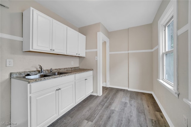 3692 E 118th St, Cleveland, OH 44105 - kitchen with a sink, wood finished floors, white cabinets, and healthy amount of natural light