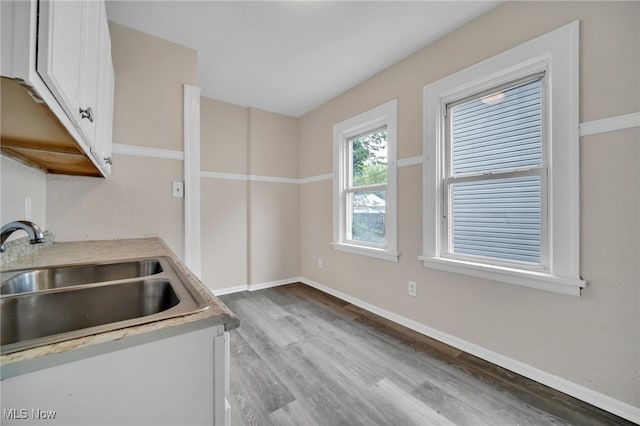 3692 E 118th St, Cleveland, OH 44105 - kitchen featuring a sink, wood finished floors, white cabinets, baseboards, and light countertops