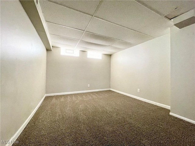 below grade area featuring carpet, a drop ceiling, and baseboards