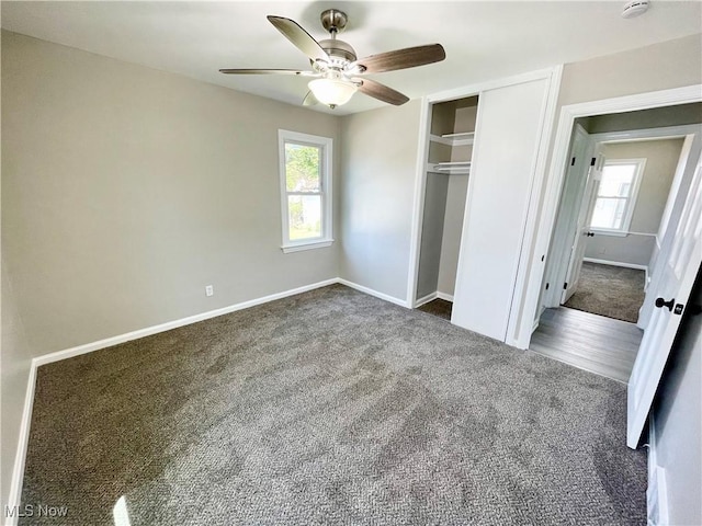 unfurnished bedroom featuring carpet, multiple windows, and baseboards
