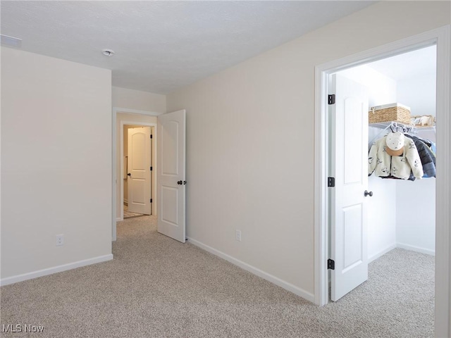 unfurnished bedroom with light colored carpet and baseboards