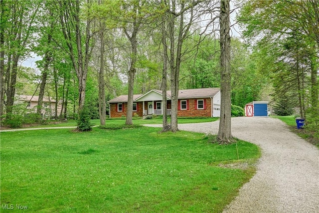 1463 Brimfield Dr, Kent, OH 44240 - ranch-style home with driveway, a front lawn, an outbuilding, a storage unit, and brick siding