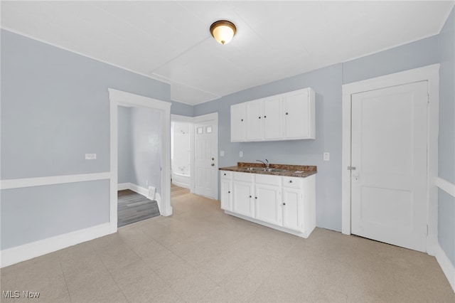 2040 W 103rd St, Cleveland, OH 44102 - kitchen featuring white cabinetry, baseboards, a sink, and light floors