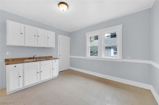 2040 W 103rd St, Cleveland, OH 44102 - kitchen with a sink, white cabinetry, baseboards, and dark stone countertops