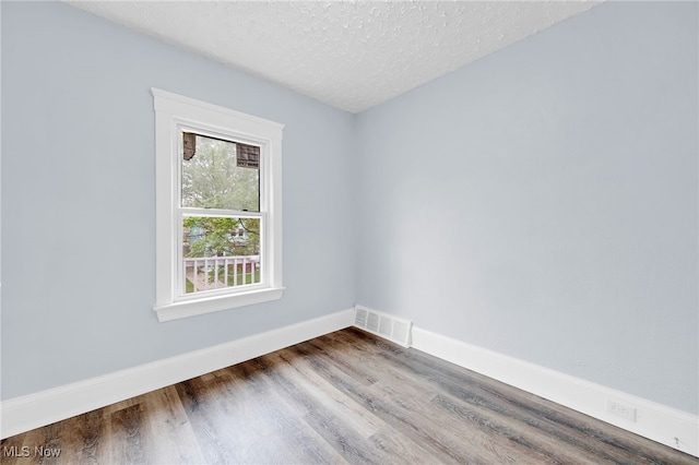 2040 W 103rd St, Cleveland, OH 44102 - spare room with wood finished floors, baseboards, and a textured ceiling