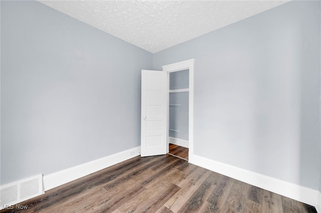 2040 W 103rd St, Cleveland, OH 44102 - unfurnished bedroom with a textured ceiling, dark wood finished floors, and baseboards