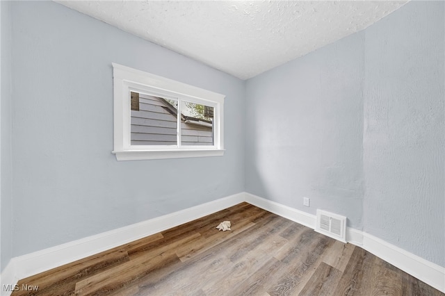 2040 W 103rd St, Cleveland, OH 44102 - empty room with wood finished floors, a textured ceiling, and baseboards