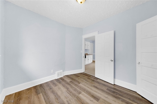 2040 W 103rd St, Cleveland, OH 44102 - empty room featuring wood finished floors, a textured ceiling, and baseboards