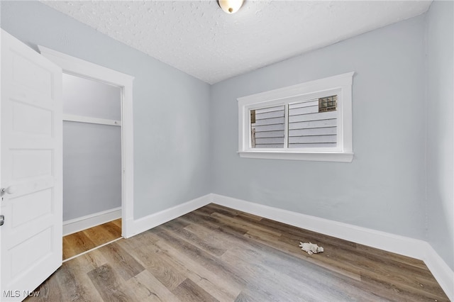 2040 W 103rd St, Cleveland, OH 44102 - unfurnished bedroom featuring wood finished floors, baseboards, and a textured ceiling