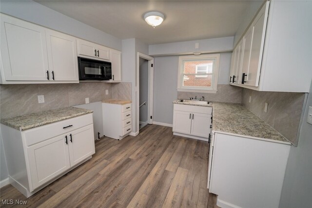 459 N Osborn Ave, Youngstown, OH 44509 - kitchen with black microwave, a sink, wood finished floors, and backsplash