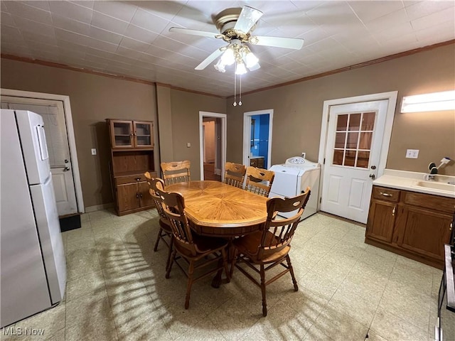 1315 18th St SW, Canton, OH 44706 - dining area with washer / clothes dryer, crown molding, a ceiling fan, and light floors