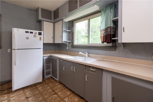 114 Mendel Ct, Elyria, OH 44035 - kitchen featuring freestanding refrigerator, a sink, light countertops, and open shelves