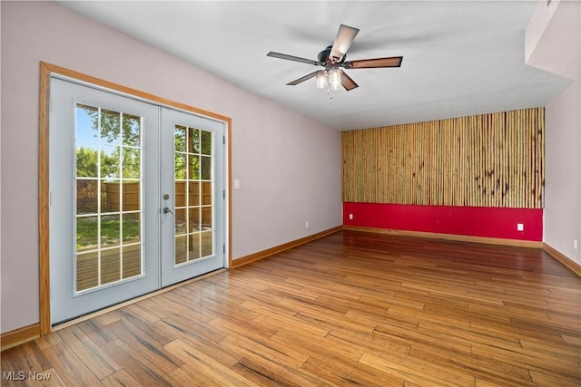 1287 E Garnet Ave, Port Clinton, OH 43452 - spare room featuring french doors, hardwood / wood-style flooring, a ceiling fan, and baseboards