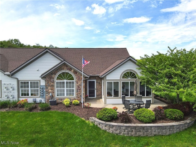 683 Crossings Cir, Tallmadge, OH 44278 - back of house featuring stone siding, a patio area, a yard, and central AC