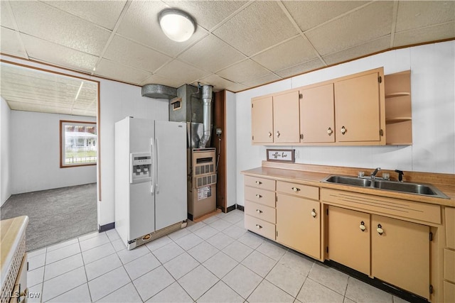 kitchen featuring white refrigerator with ice dispenser, a drop ceiling, a sink, open shelves, and light tile patterned flooring