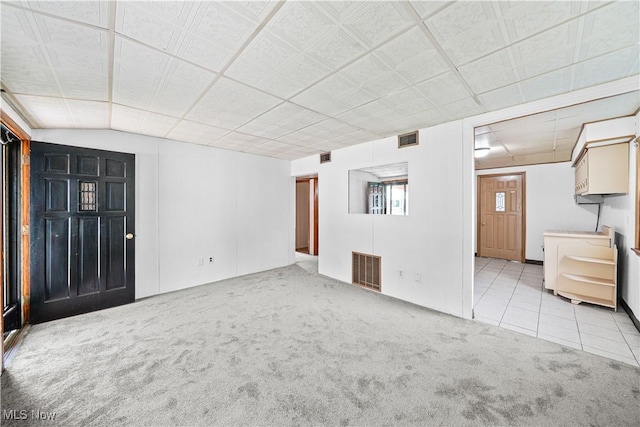 unfurnished living room featuring carpet and tile patterned floors
