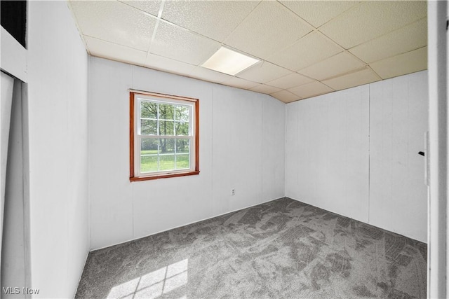 unfurnished room featuring carpet flooring and a drop ceiling