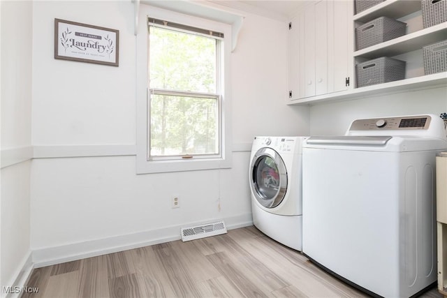 675 Wheatfield Dr, Aurora, OH 44202 - laundry area with washer and dryer, cabinet space, and light wood-style floors