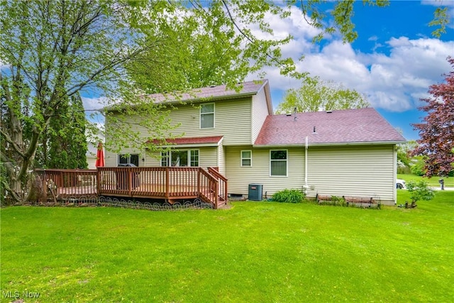 rear view of house with a lawn, a deck, central air condition unit, and roof with shingles