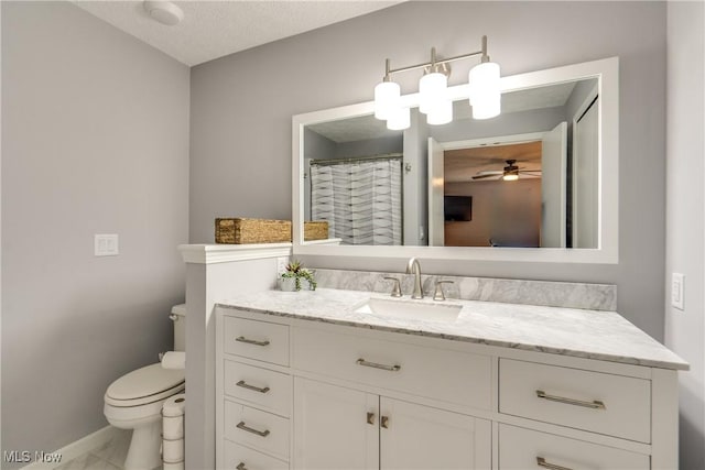 full bath with toilet, vanity, ceiling fan, and baseboards