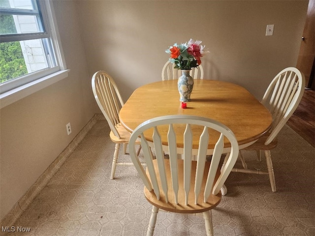dining space featuring tile patterned floors and baseboards