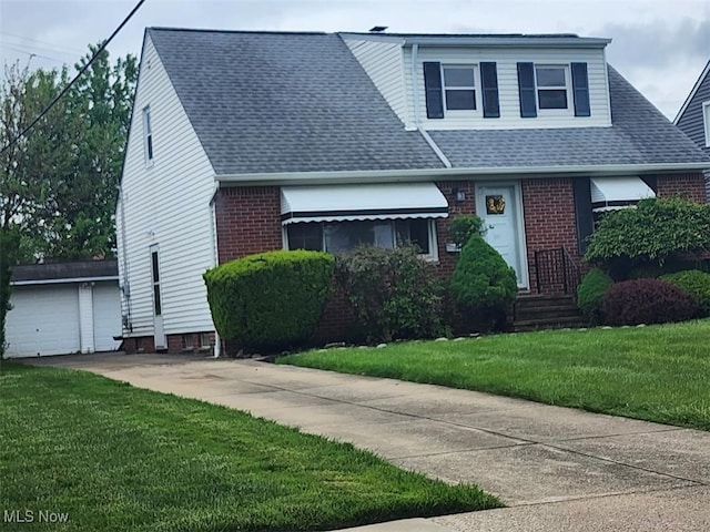 view of front of home with brick siding, a front lawn, and a shingled roof