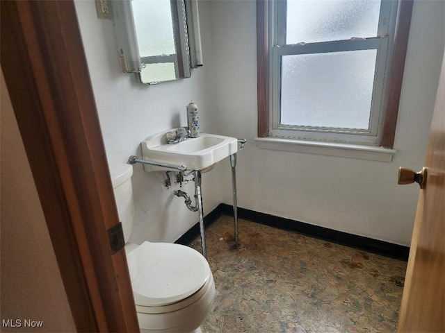 half bath featuring healthy amount of natural light and toilet