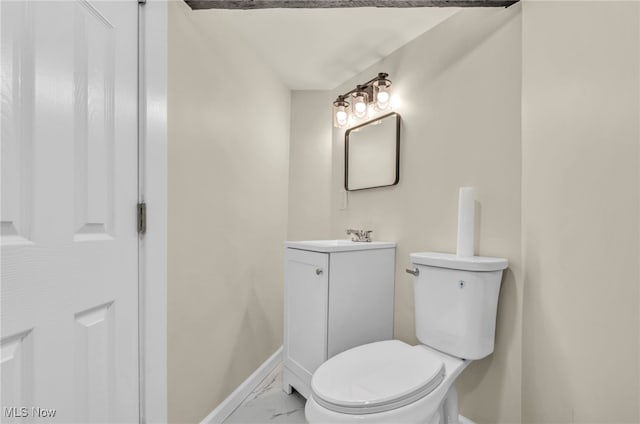bathroom with marble look tile flooring, baseboards, toilet, and vanity