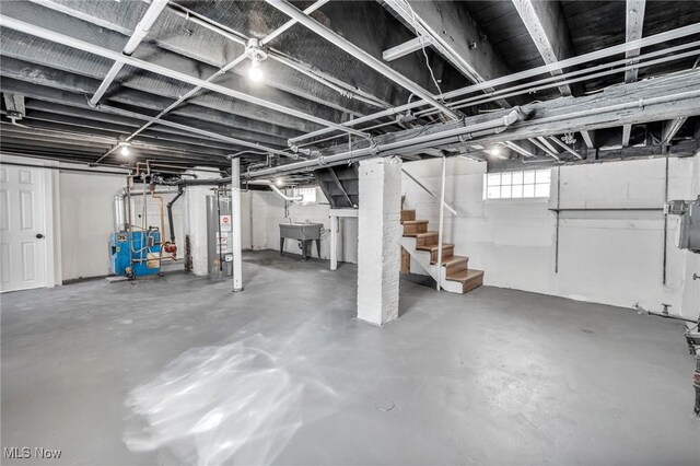 basement with stairway, gas water heater, a sink, and a heating unit