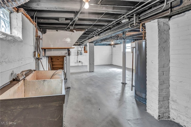 basement featuring gas water heater and a sink